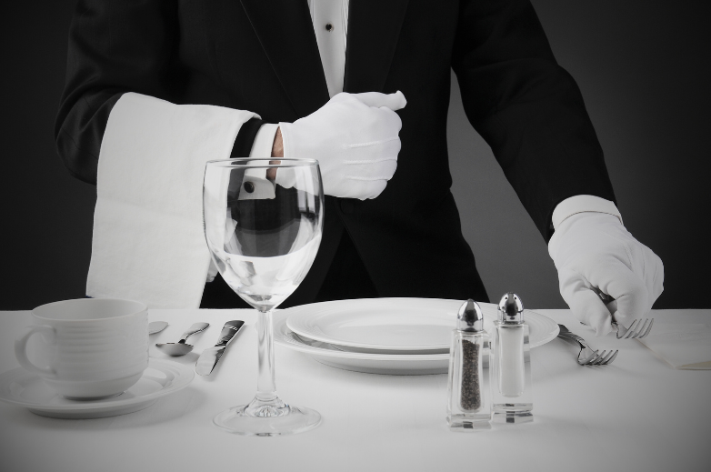 waiter setting table at fine dining restaurant