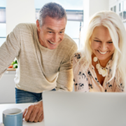smiling middle age couple looking at computer