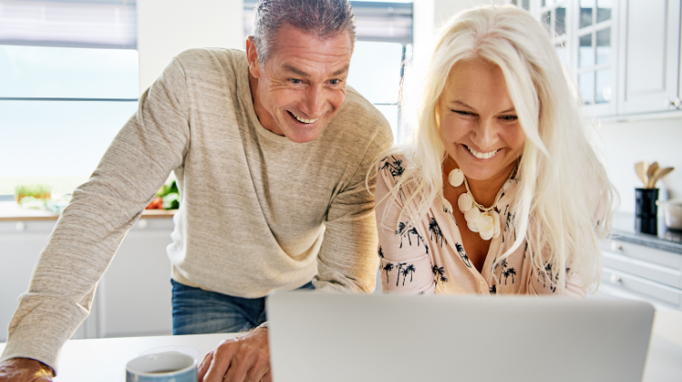 smiling middle age couple looking at computer