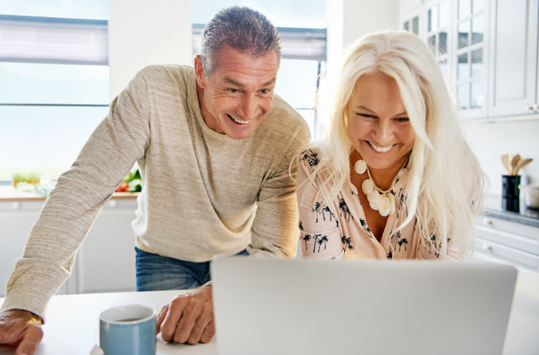 smiling middle age couple looking at computer 